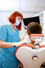 Obraz premium Image of young lady with dentist over her checking oral cavity .