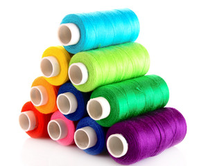 Pyramid of many-coloured bobbins of thread isolated on white