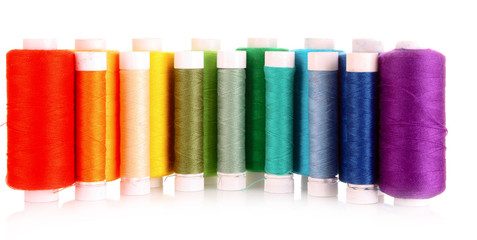 Semicircle of many-coloured bobbins of thread isolated on white