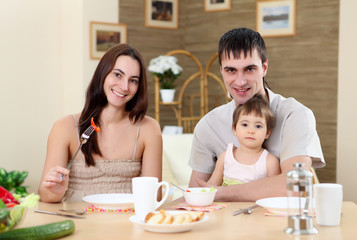 Obraz na płótnie Canvas young family at home having meal