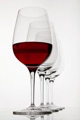 row of four wine glasses, first ist filled