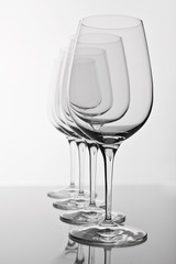 row of four empty wine glasses