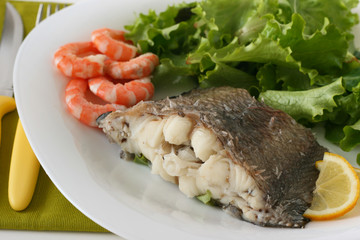 Fototapeta na wymiar boiled fish with shrimps, lemon and salad