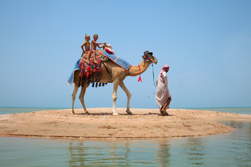 Two children ride a camel
