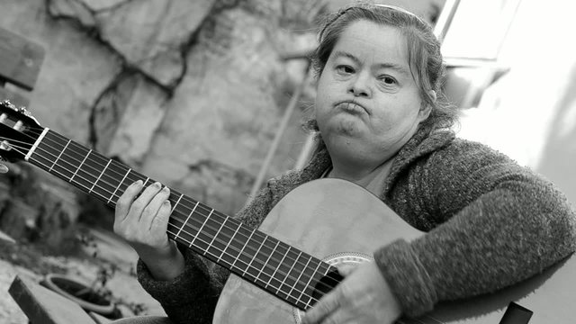 down syndrome woman playing on guitar
