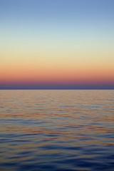 Naklejka na ściany i meble Beautiful sunset sunrise over blue sea ocean red sky