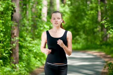 Fototapeta premium Beautiful woman running in green park