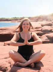 Fototapeta na wymiar Woman enjoying yoga at the beach in Nova Scotia