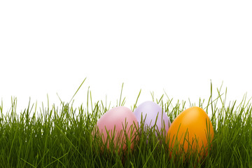 drei pastellfarbene ostereier in gras vor weissem hintergrund
