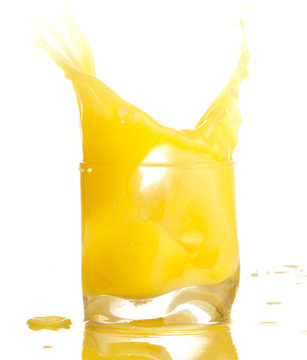 orange juice splashing on a glass on white background