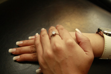 Left hand with diamond ring over right hand
