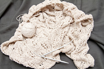 a beige knitted shawl with round needles
