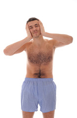 Fototapeta premium Young handsome man in underware waking up in the morning and yaw