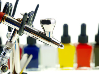 Airbrush-Spritzpistole mit Flaschen in verschiedenen Farben freigestellt auf weißem Hintergrund