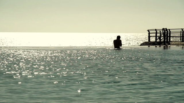 Silhouette of man sitting in the water
