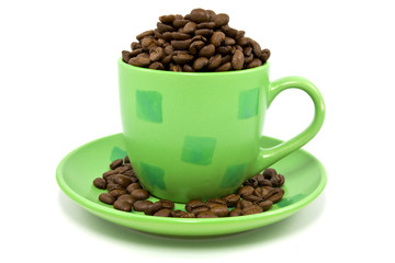 green cup with coffee beans over a white background