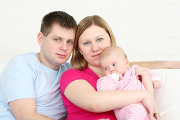 Happy family with the chest baby on hands