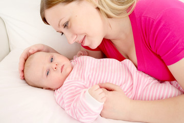 Fototapeta na wymiar Young mum embraces the falling asleep chest baby