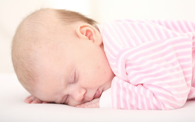 Fototapeta na wymiar sleeping baby in striped toddlers close up