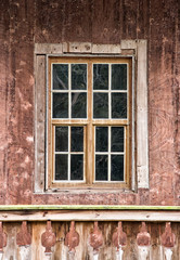 Very old wooden window in the wall of cottage