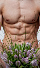 Sexy muscular boy with bouquet of tulips
