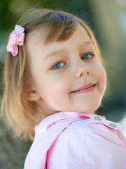 beautiful little girl in a pink raincoat