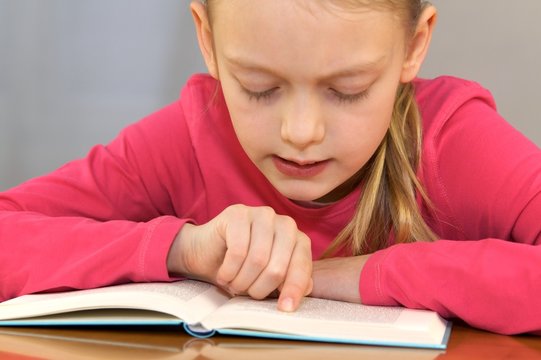M&auml;dchen liest aus Buch vor