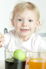 little girl during Easter eggs' coloration