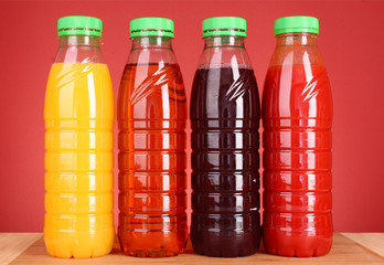 bottles of juice on red  background