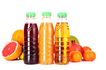 bottles of juice  with ripe fruits on white background