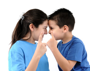 Cute boy and teen girl pointing fingers at each other isolated