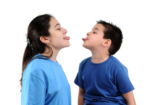 Cute boy and teen girl  stick out their tongues isolated.
