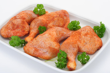 Frische Hähnchenkeulen auf Porzellanplatte