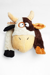Part of funny soft toy cow on white with selective focus