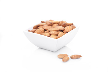 Bowl of almonds isolated on white background