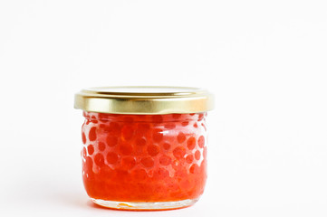 a glass jar with red salmon caviar