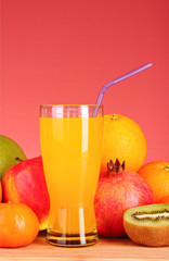 bottles of juice  with ripe fruits on yellow background