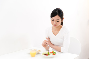 Obraz na płótnie Canvas beautiful asian woman eating breakfast