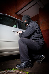 robber and the thief in a mask hijacks the car