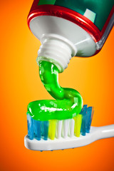 toothpaste being squeezed onto a toothbrush - obrazy, fototapety, plakaty