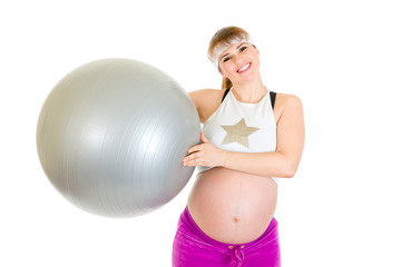 Happy pregnant woman in sportswear holding fitness ball