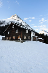 Verschneite Hütte im Gebirge