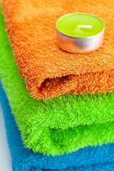 background of the three multi colored terry towels and candle
