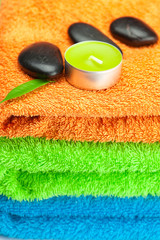 Obraz na płótnie Canvas background of the three multi-colored bath towels, black spa sto