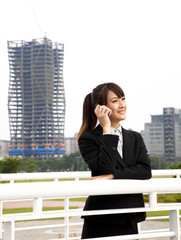 Happy asian business woman talking on the phone