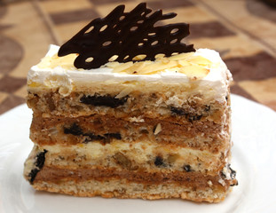 piece of cake with prunes, chocolate and almonds on plate