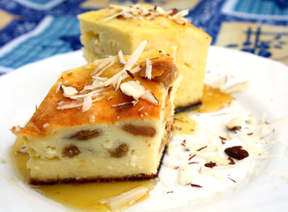 curd pie with raisin, honey and almond on white plate