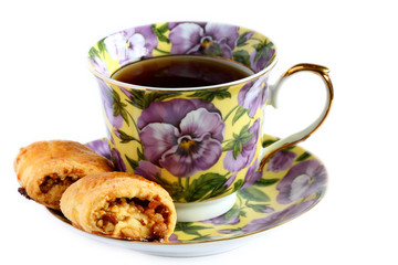 isolated cup of tea with cookie on saucer