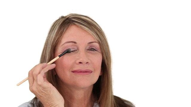 Elderly woman putting on make-up