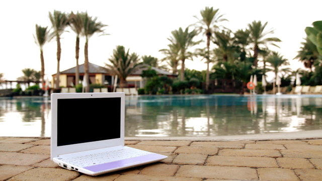 Netbook near to swimming pool